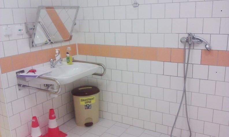 WC společné s bezbariérovou sprchou I zde je vstup přes posuvné dveře šířky 1170 mm. Také chybí madlo. Vypínač je umístěn v maximální možné výšce 1200 mm nad podlahou.