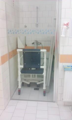 Bezbariérová sprcha samostatná Průchozí místnost obsahuje jak otevřenou sprchovací plochu, tak sprchovací box. Dále se v místnosti nachází záchodová mísa a umyvadlo.