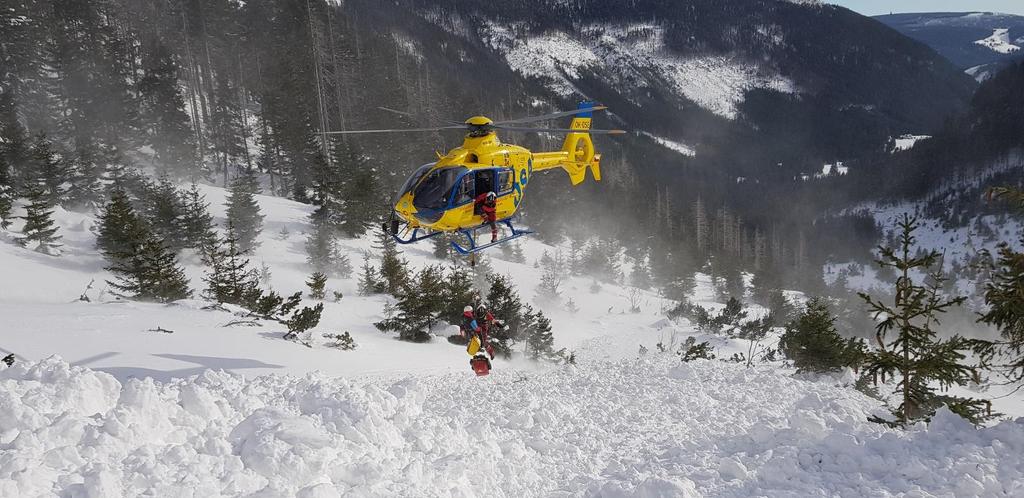 Jeden ze záchranářů začíná při sjíždění lavinou prohledávat laviniště pomocí lavinového přístroje. Kousek u konce laviny má prvotní signál a za chvíli je nad zasypaným skialpinistou.