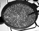 uvaříme to doměkka. Na slanině osmažíme cibuli, mrkev a klobásku nakrájené na kostičky. Přidáme trochu vody z fazolí, protlak a vše podusíme do měkka.