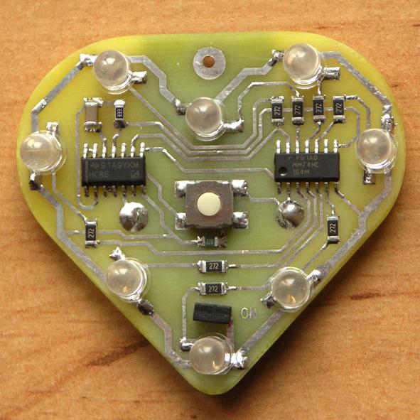 Z hradel U1A, U1B a U1D je sestaven astabilní multivibrátor, který slouží jako hodinový signál CLK pro posuvný registr.