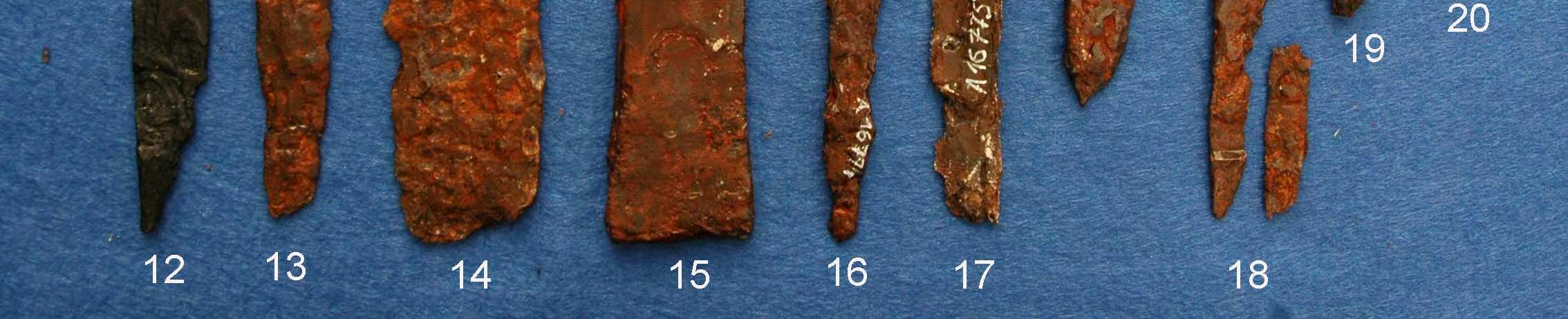 z hrobu H58/90, tvořený přehnutým pásem železného plechu, interpetovatelný jako kovové pouzdro se zasunutou čepelí uvnitř. Byl nalezen v oblasti pravého kolene.
