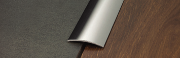 Profily pro podlahy o stejné výšce Proclassic vyrábíme v různých délkách a z různých materiálů. Ploché profily z hliníku mají užitečné protiskluzové rýhování a nevytváří tlustý prvek pode dveřmi.