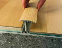 Pomocí dřevěné podložky a kladiva postupně narazit přechodový profil. Using a wood pad and a hammer tap the cover strip gradually.