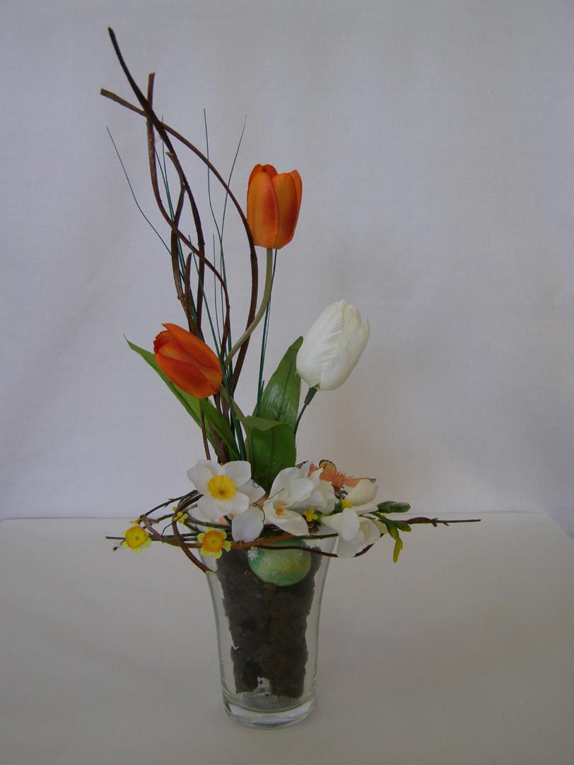 Do kôry sú vsadené umelé tulipány a konáre.