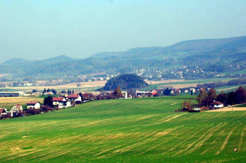 Obr. 8. Plochý reliéf Rtyňské Brázdy mezi Malými Svatoňovicemi a Rtyní v Podkrkonoší. Uprostřed Čertův vršek, v pozadí hřeben Jestřebích hor. 6. Současné geodynamické procesy 6.1.