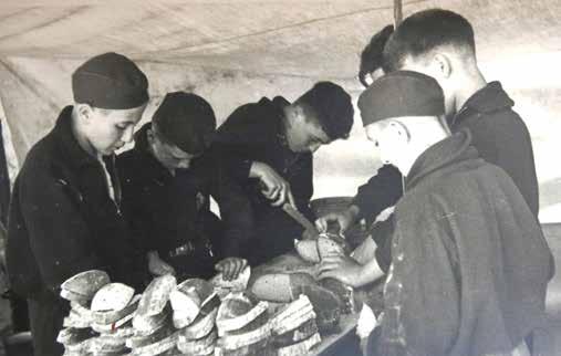 Příprava snídaně na táboře Tchelet Lavan o prázdninách roku 1938. Mathias Kohn (Matti Cohen) třetí zleva.