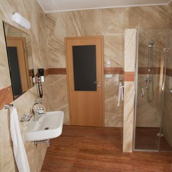 dvoulůžkový apartmán/suite s manželskou postelí koupelna se sprchovým koutem nebo vanou, WC, fén, župan (vratná kauce), pantofle