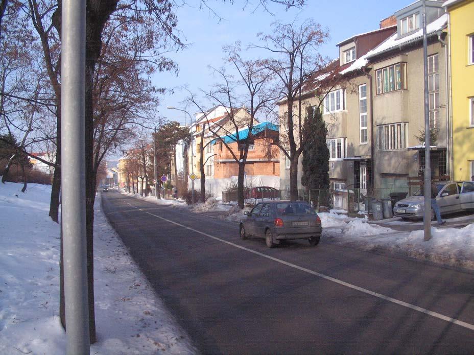 - 22 - Obrázek nahoře zachycuje současný stav ulic Bělohorské a Podlomní v záběru z podesty schodiště. Protože stromy zakrývají výhled, je druhý snímek záběrem z chodníku.