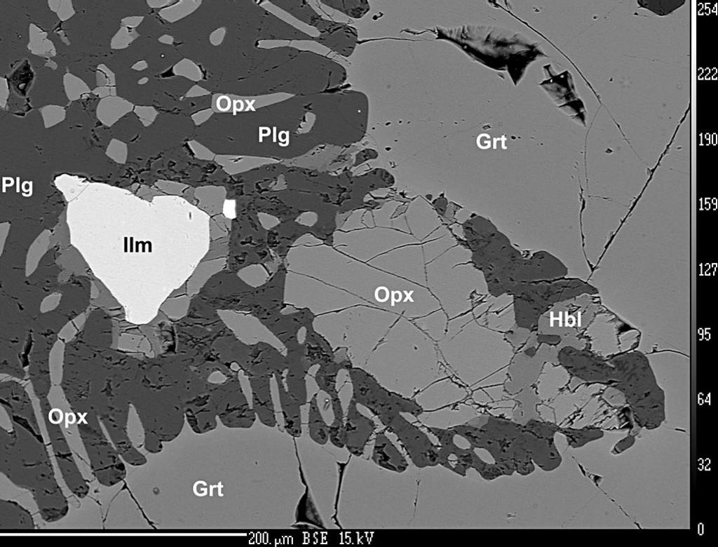 21 Postavení ortopyroxenu (Opx) ve struktuře horniny s amfibol-plagioklasovými (Hbl+Plg) a ortopyroxen -plagioklasovými (Opx+Plg) symplektity, s amfibolem (Hbl) a ilmenitem (Ilm).