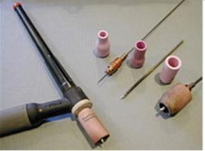 Obrázek 60: Svařovací hořák s elektrodami, měděnými kontaktními špičkami a keramickými (růžovými) plynovými hubicemi [35] Obrázek 61: Rozebraný