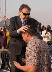 Predání pochodne Reinhard Bonnke se modlí za Daniela Kolendu. Uvolňuje Boží požehnání pro příští fázi práce CfaN. Od této chvíle ponese hořící pochodeň CfaN Daniel Kolenda.