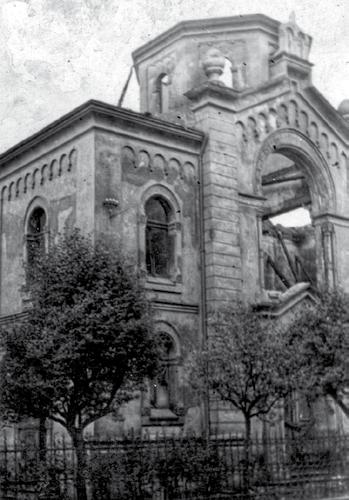Vypálená sokolovská synagoga po tzv. Křišťálové noci, 10. listopadu 1938. V roce 1901 bylo schváleno a realizováno nové oplocení oddělující synagogu od komunikace a tělocvičny.