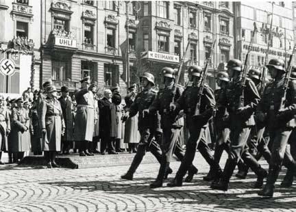 Přehlídka wehrmachtu na Václavském náměstí v Praze 5. dubna 1939. Na tribuně stojí nově příchozí říšský protektor Konstantin von Neurath a prezident Emil Hácha.