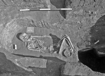Dolní končetiny pohřbené ženy jsou pokrčeny a respektují hranici objektu 93, ve kterém byla nalezena kompletní kostra kozy nebo ovce. Foto T. Mořkovský. Abb. 4.