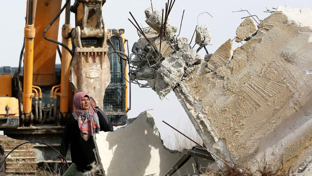 Palestinská žena se snaží zabránit demolici svého domu Izraelci.