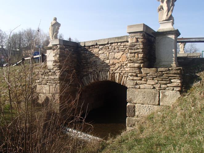 1 Výmol za kmenem vytvořený vodou přetékající přes korunu hráze při povodni. 36 Obr. 2 Replika mostu z r. 1891.