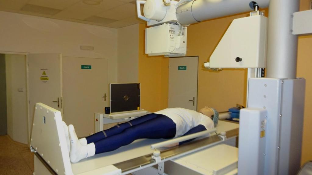 Obrázek 28: Připravené pracovní pomůcky na radiologickém pracovišti před zahájením měření fixní rtg přístroj, antropomorfní fantom, kazeta s připevněným olovem a dozimetr.