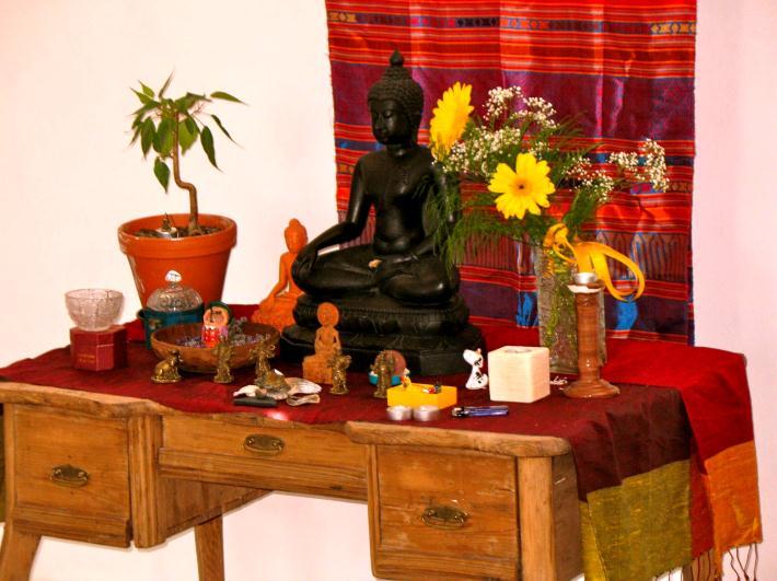 Obr. 7 Socha Buddhy v rodině respondenta ze skupiny théravádového buddhismu. V popředí je vidět několik plastových hraček. Mariánské Lázně 15. 5. 2007 Vedle soch jsou umisťovány květiny a svíčky.