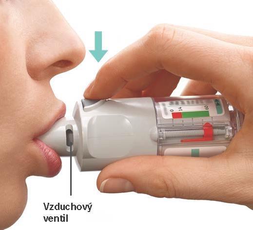 Během pomalého a hlubokého nádechu ústy STISKNĚTE prstem tlačítko uvolňující dávku a pokračujte v pomalém nádechu tak dlouho jak je to pro Vás možné.