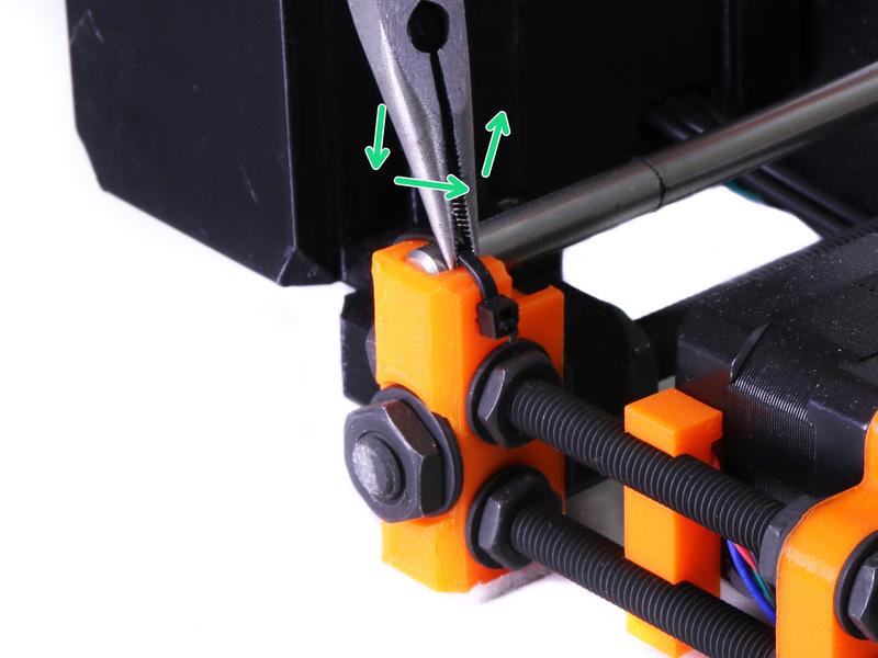 Postavte tiskárnu zpátky na nohy a kleštěmi povolte 4 stahovací pásky, které drží hlazené tyče.
