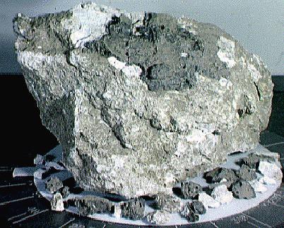 Obr. 3 Anortozit (tlakově postižený). Vzorek z Apolla 16, z pevninské oblasti poblíž kráteru Descartes, stáří kolem 4,4 miliard let, velikost asi 14 cm krát 10 cm. Převzato z [19].