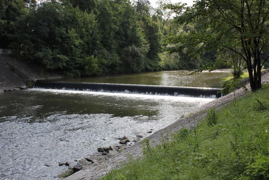 První spádový stupeň se nachází v profilu nad zaústěním Sadového potoka. Koryto je v místě objektu opevněno kamennou dlažbou, spádová výška objektu činí 2,3 m.