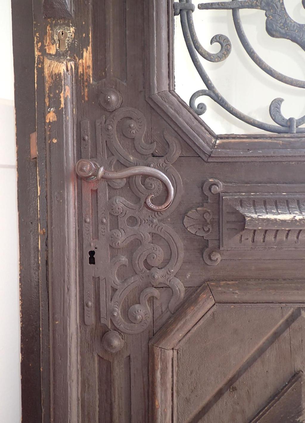 OBR. Č. 4 Hlavní dveře - stav v době průzkumu detail kování vnější strana. Na snímku je vidět kování doplňující zdobné kovové aplikace na dveřích.