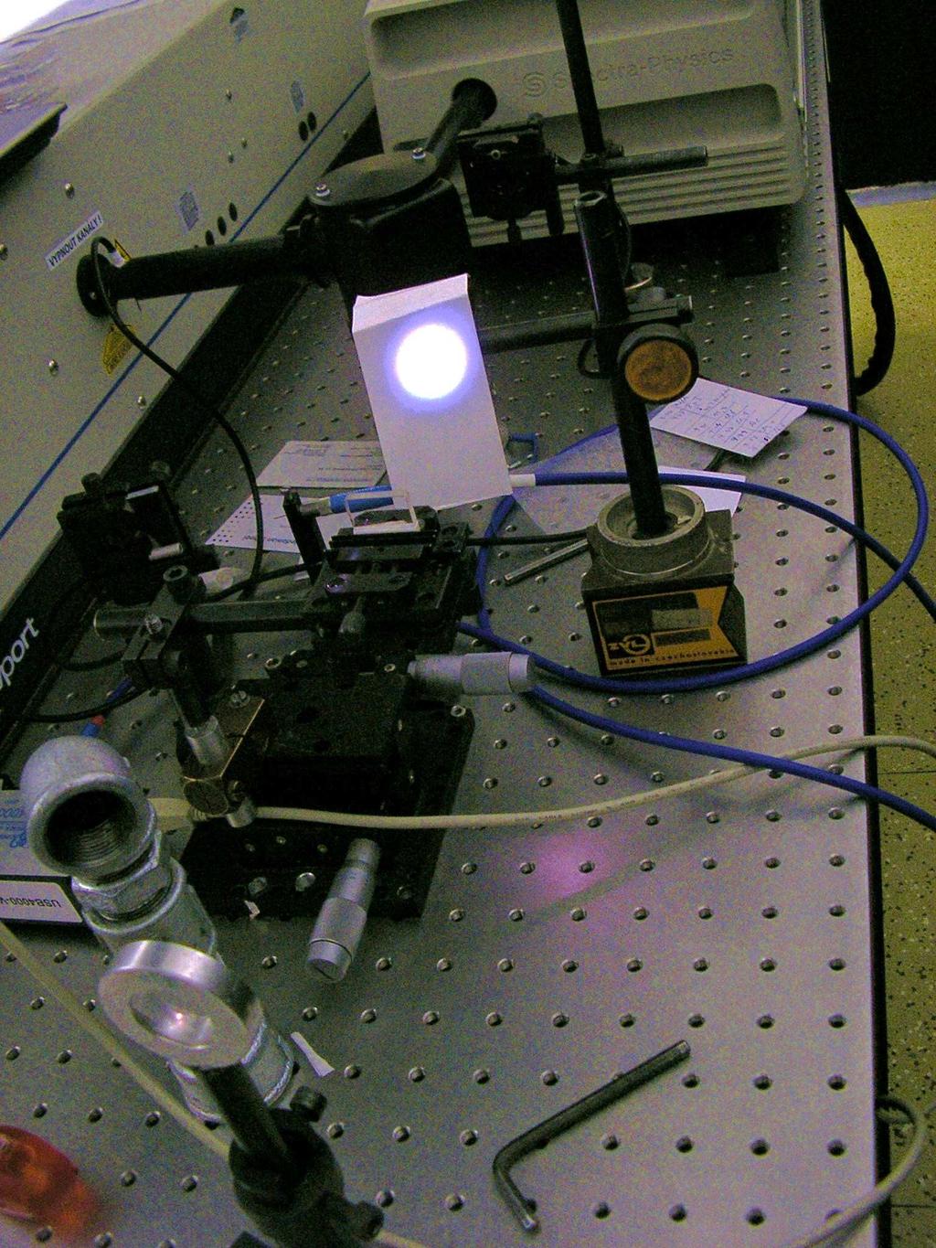 Schéma měření Pulsy generované laserem byly pomocí stříbrných zrcadel přivedeny na spojnou čočku. Pro regulaci intenzity pulsů bylo možno před čočku vkládat šedý filtr.