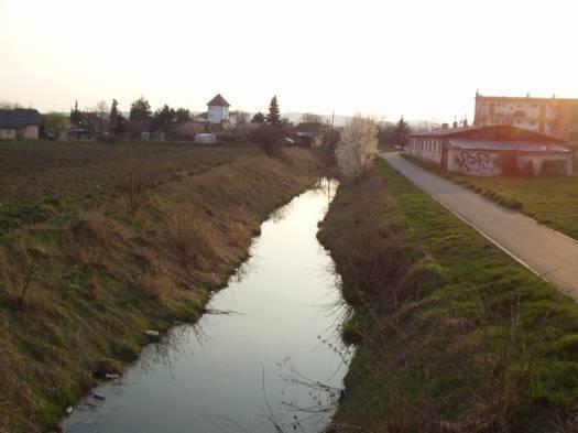 Pohled po vodě. Pohled z mostu proti vodě.