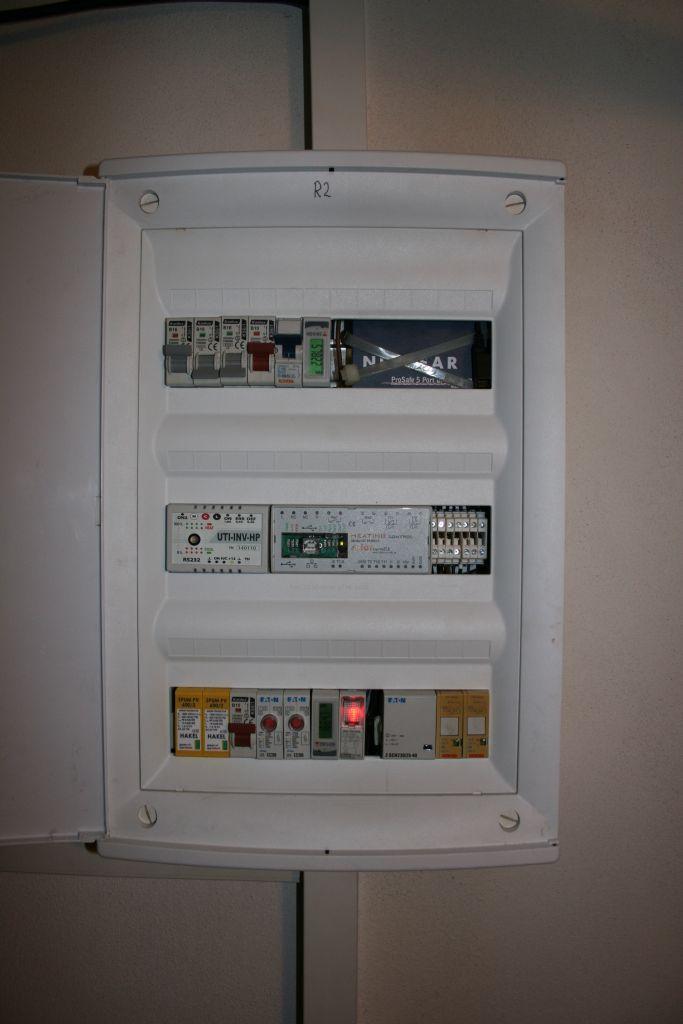 A také elektroměr EM2 a ethernetový switch. V prostřední části je umístěn Heating Control a modul UTI-INV-HP.
