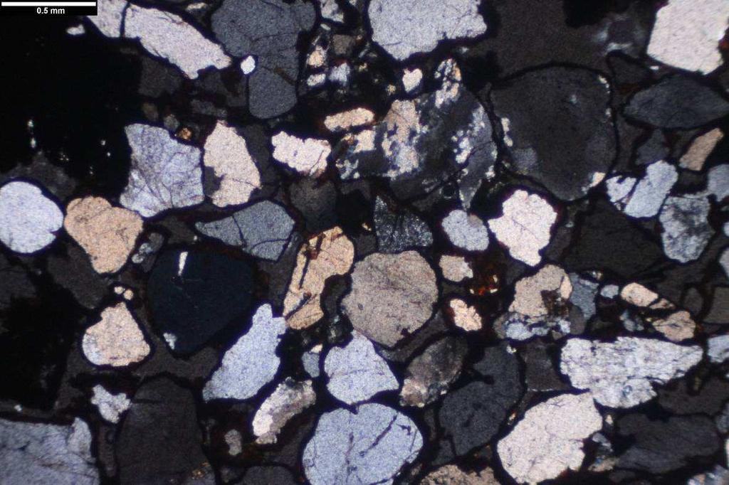 Vzorek KM-ZE2 Makropopis: klastická sedimentární hornina s hojným tmelem tvořeným Fe-oxyhydroxidy, které dodávají rudohnědé zbarvení.