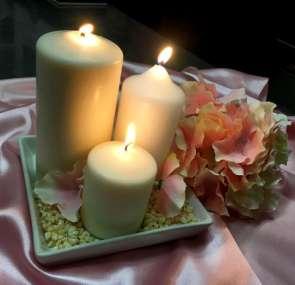 Bílé keramické talířky se svíčkami dozdobené kamínky a