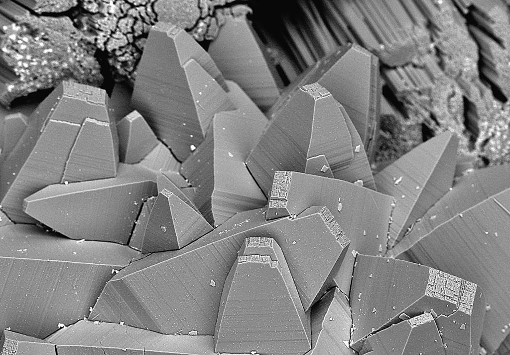 15 Skupina dokonale vyvinutých krystalů tschernichitu z Jehly, šířka obrázku 800 μm BSE foto B. Ekrt. Obr. 16 Srůsty krystalů tschernichitu s jehlicovitým erionitem-k z Jehly, šířka obrázku 1.