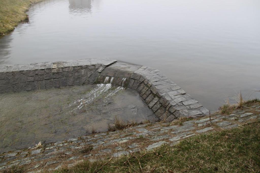 s přepadovou šachtou. Mezi oběma šachtami se nachází dlužová stěna, se kterou lze manipulovat ze vstupní šachty. Na vrcholu násosky je umístěna ruční pumpa pro odčerpání vzduchu z násosky.