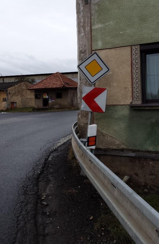 Obrázek 2 Nároží budovy s nedostatečným úzkým průjezdem [2] Obrázek 3 Zdevastované nároží budovy [2] Nevhodné řešení silnice