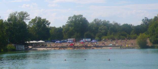 Pláž na Stříbrném jezeře. Intenzívně využívaná lokalita v období horka s dostupností služeb a sportovních aktivit.