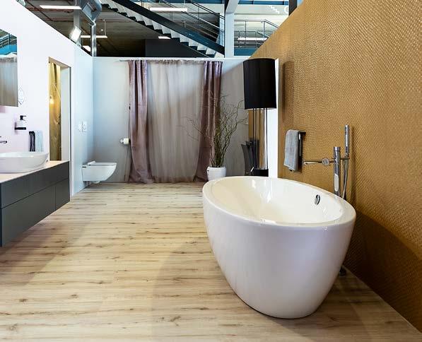 Na méně exponované stěně byla aplikována vinylová tapeta ve zlaté barvě, před kterou dominovala volně stojící vana. části. Pracovní desku zvolila designérka z kompaktu.