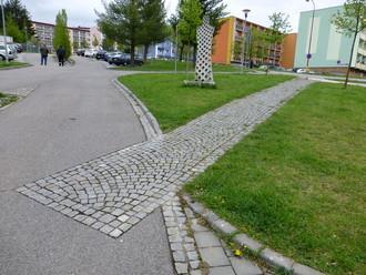 parkovacími plochami a širokými vozovkami kvůli vysokým požadavkům na dopravní obslužnost.