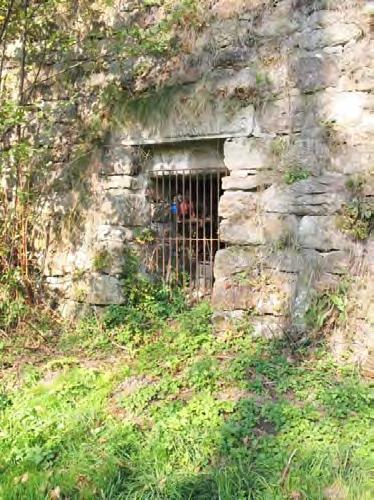 Historie hutnictví Obr. 8 Uzavřený vstup do štoly v kamenné stěně zrušeného železničního náspu (foto L. Stránský r. 2012). Fig.