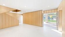 Interiér umocňují velkoformátová okna a designové dřevěné žaluzie.