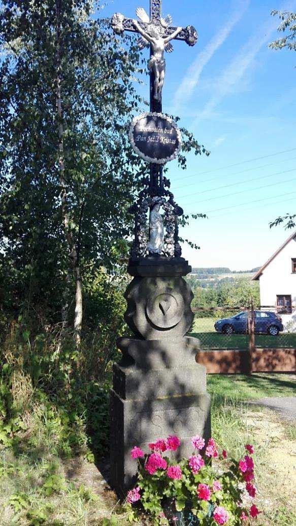 1869); původně stál asi o 30 m výš, u pravotočivé zatáčky silnice vedoucí na Osuli byl