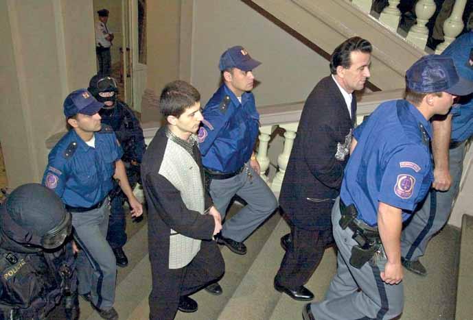 foto čtk Spravedlnost s příchutí policejní pomsty. (Podzim 2000, otec a syn Hanušové míří k soudu) Rány lékaři označili za smrtelné zranění.