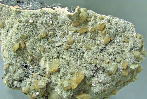 Obr. 6. Krystaly wulfenitu narůstající na žilovinu z lokality Tsumeb v Namibii, velikost ukázky 11 x 6,5 x 6 cm. Foto: D. Velebil.