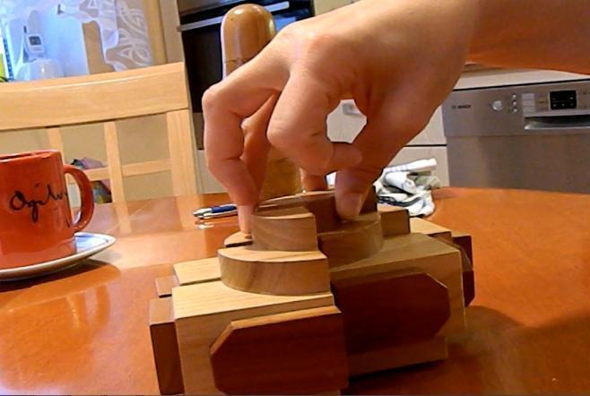 DŮM 4 dílný kvádr, při správném (výchozím) složení jsou na jeho stěnách osově souměrné geometrické útvary vystupující válcovité útvary na