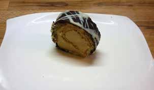 zdobený bílou čokoládou ROLÁDA OŘECHOVÁ-ARAŠÍDY piškotový plát, máslový ořechový krém, obalený v ořechách ROLÁDA