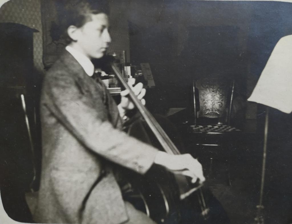 MLADISTVÝ VÁCLAV ŠEBEK, HRAJÍCÍ NA VIOLONCELLO. NA FOTOGRAFII JSOU PATRNÉ JEHO DLOUHÉ PRSTY, PŘÍZNIVÁ DISPOZICE PRO KARIÉRU GYNEKOLOGA.