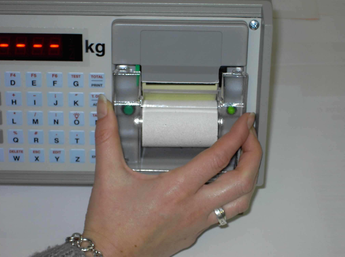 8. Tiskárna: 8. Interní tiskárna Posuv papíru: Stiskněte zelené tlačítko posuvu papíru. (pod čelní deskou tiskárny). Výměna papíru v tiskárně: Otevřeme čelní desku tiskárny.