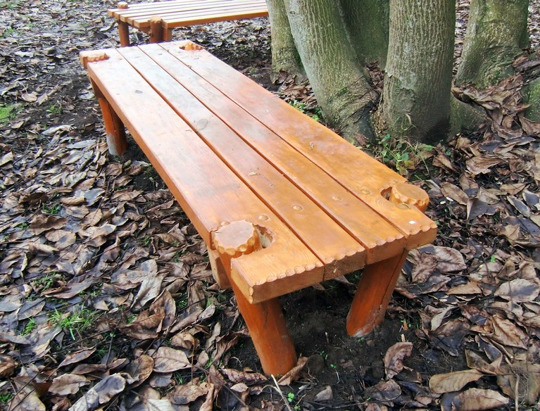 Dřevěná lavička bez opěradla široká Popis: jednoduchá dřevěná lavice z akátových fošen a kulatiny, spojená šrouby a zapuštěná do země ve dvou mírně odlišných provedeních.