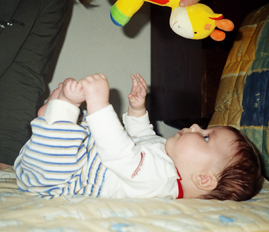 kondylem kolene. Dítě potom přetočí osu ramen, dotočí trup na bříško a opře se o lokty. V lehu na zádech si díky zvýšené flexi dolních končetin a pánve chytá prsty u nohou a dává si je k ústům.